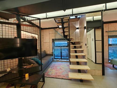 a living room with a staircase and a tv at loft apartments OLD MILL in Sarny