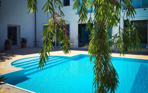 a blue swimming pool in front of a building at Casa Solares in Solfara Mare