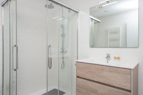 een badkamer met een glazen douche en een wastafel bij Sa Riba in Muro