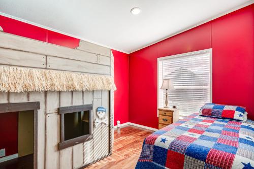 a bedroom with red walls and a bed and a tv at La Verkin Home with Yard, Covered Patio and Grill in La Verkin