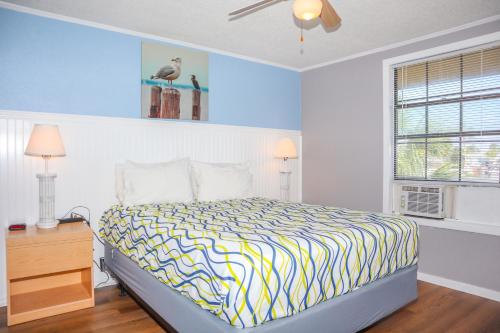 a bedroom with a bed with a yellow and blue comforter at River Wilderness Waterfront Cabins in Everglades City