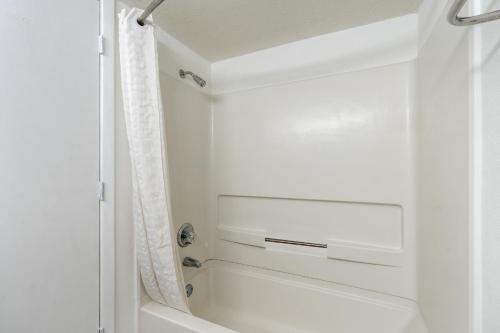 a bathroom with a white tub and a shower at The Mermaid Inn in Myrtle Beach