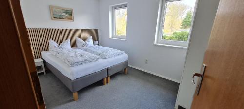 a bedroom with a bed with white sheets and pillows at Komfortabele Ferienwohnung in ruhiger Lage in Sassnitz