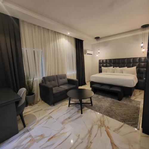Habitación de hotel con cama y sofá en melbrookeparkhotel en Lagos