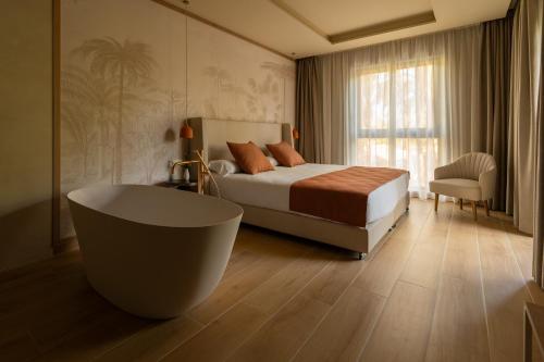 a bedroom with a bed and a bath tub in it at Jardín Milenio in Elche