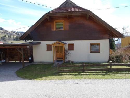 a house with a brown and white at Chalet in Diex near Klopeiner See with sauna in Diex