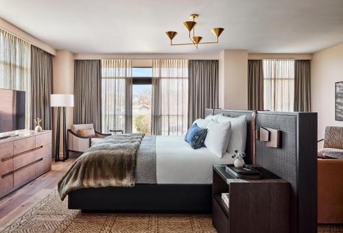a hotel room with a bed and a television at Bowie House, Auberge Collection in Fort Worth