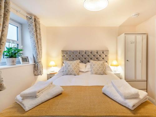 een slaapkamer met een groot wit bed met 2 kussens bij 1 Bed in Lytham 86044 in Saint Annes on the Sea