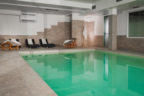 a swimming pool with blue water in a building at The Regent Boutique Hotel & Spa PRE OPENING in San Marino