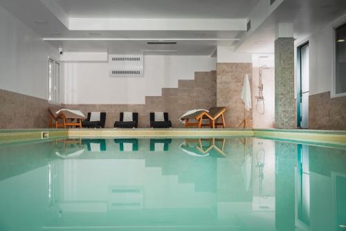 a swimming pool with chairs and tables at The Regent Boutique Hotel & Spa PRE OPENING in San Marino