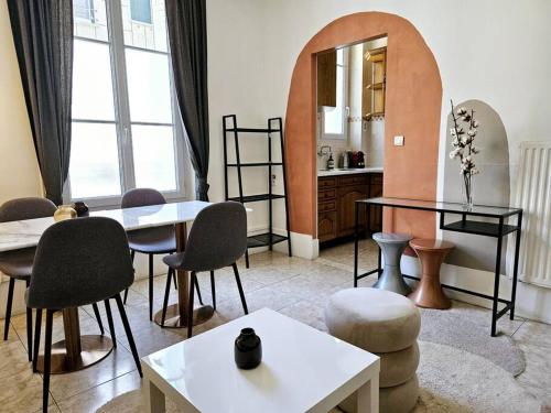 un salon avec des tables, des chaises et un miroir dans l'établissement The Theodora Suite - Duke Housing, à Vitry-sur-Seine