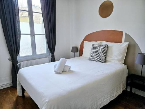 ein weißes Bett mit einem Teddybär drauf in der Unterkunft The Ground Floor Suite in Vitry-sur-Seine
