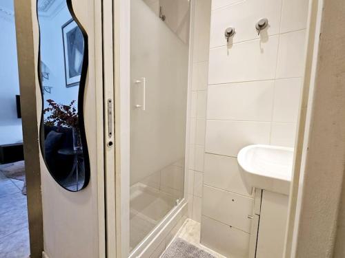 une salle de bain blanche avec une douche et un lavabo dans l'établissement The Theodora Suite - Duke Housing, à Vitry-sur-Seine