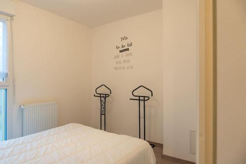 - une chambre avec deux lumières sur le mur et un lit dans l'établissement Le Réséda, maison avec jardin, à Saint-Valery-sur-Somme