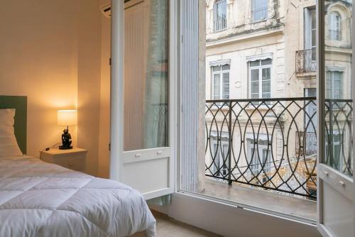 une chambre avec un lit et une grande fenêtre dans l'établissement Le Sauge, Charmant Loft, Clim, Proche Comédie, à Montpellier