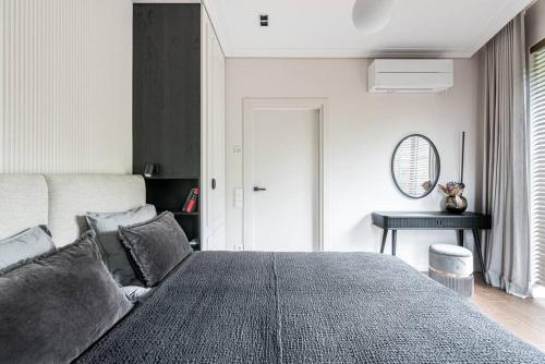 ein Schlafzimmer mit einem großen Bett und einem Tisch in der Unterkunft Spacious luxury apt w/river view/terrace Paupys in Vilnius