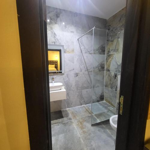 a bathroom with a shower and a sink and a toilet at melbrookeparkhotel in Lagos