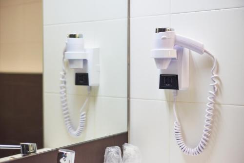a bathroom with two phones on the wall at RR Alvor Baía Resort in Alvor