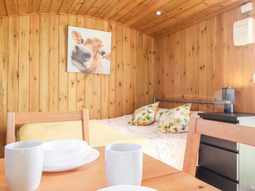 a small room with a bed in a wooden wall at Maquessa Shepherd's Hut in Dumfries