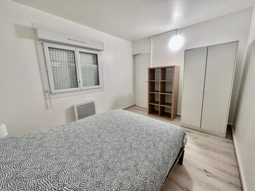 um quarto branco com uma cama e uma janela em 03 T2 Immeuble Le GD em Jarny