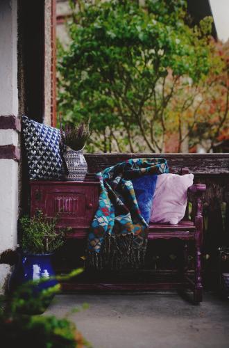 a bench with pillows and a blanket on it at Przystanek w kolorach świata in Jelenia Góra