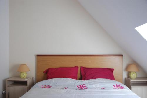 - une chambre dotée d'un lit avec des oreillers rouges et roses dans l'établissement VOTRE T3 à LUZ SAINT SAUVEUR, été hiver, à Luz-Saint-Sauveur