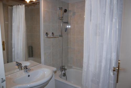 La salle de bains est pourvue d'un lavabo et d'une douche avec rideau de douche. dans l'établissement VOTRE T3 à LUZ SAINT SAUVEUR, été hiver, à Luz-Saint-Sauveur