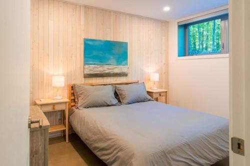 1 dormitorio con 1 cama con 2 mesas y 2 lámparas en Le coup de coeur du Lac Supérieur - 3 minutes from Tremblant! en Lac-Superieur