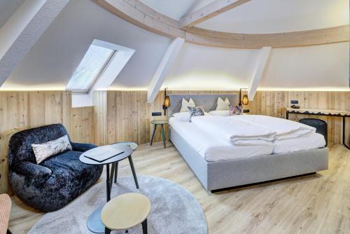 a bedroom with a large bed and a chair at Hotel Brigitte in Ischgl