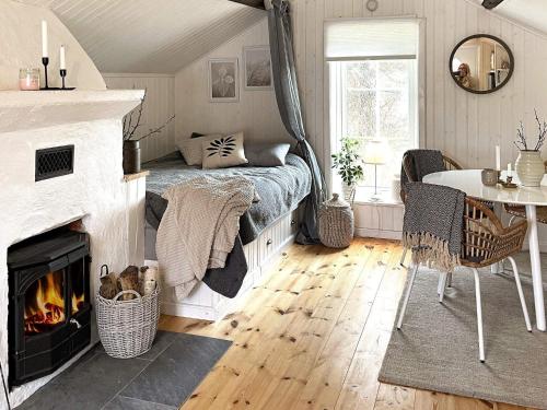 um quarto com uma lareira, uma cama e uma mesa em Holiday home VIKBOLANDET III em Arkösund