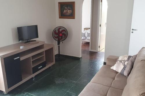 een woonkamer met een bank en een flatscreen-tv bij Let it be in Vitória