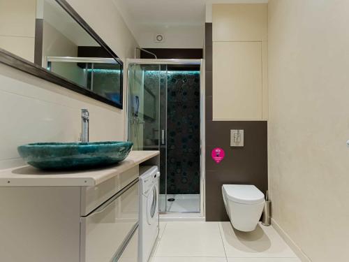 a bathroom with a sink and a toilet at VacationClub - Leśna 12A Apartament 24 in Pobierowo