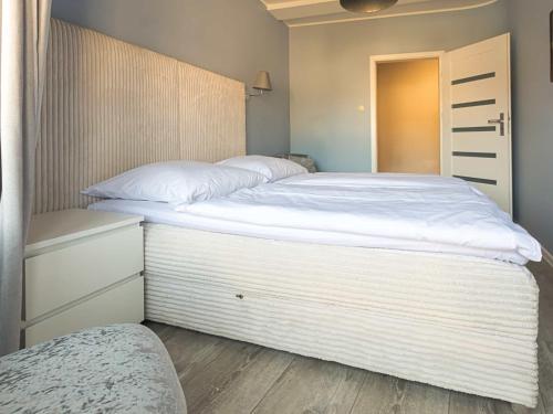 a large white bed in a small bedroom at VacationClub - Leśna 12A Apartament 25 in Pobierowo