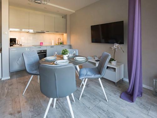 a kitchen and dining room with a table and chairs at VacationClub - Leśna 12A Apartament 25 in Pobierowo