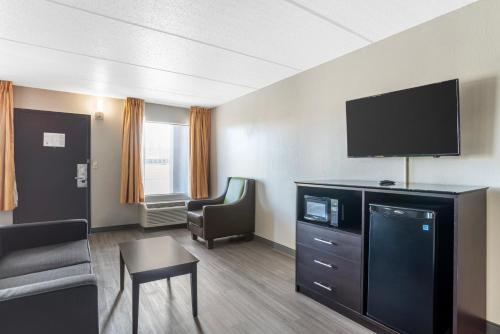 a hotel room with a tv and a couch and a chair at Quality Inn Simpsonville-Greenville in Simpsonville
