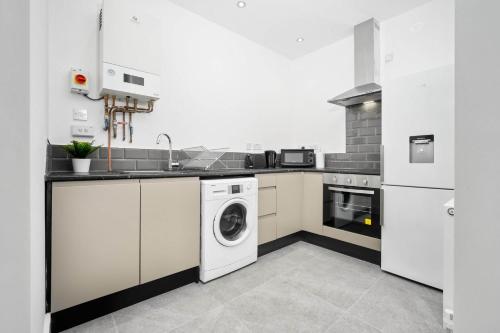 a kitchen with a washer and dryer in it at Stylish Apartment with Free Wifi & Netflix 49aG in Rowley Regis