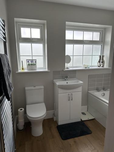 a bathroom with a toilet and a sink and a tub at Immaculate 4-Bed Cottage in Knaresborough in Knaresborough