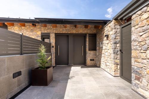 a stone building with two garage doors and a potted plant at Cases Cerdanya Mountain Residences in Bellver de Cerdanya 