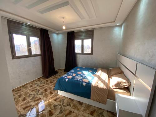 a bedroom with a bed and two windows at دار الياقوت Dar Al Yaqut in Dakhla