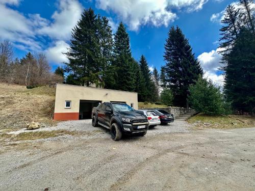 a parking lot with cars parked in front of a garage at Chata Hana Donovaly in Donovaly
