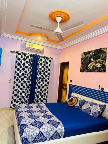 a bedroom with a blue bed and a ceiling at Passion Housse in Ouagadougou