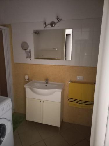 uma casa de banho com um lavatório e um espelho em MORADIAS I02/C em Prainha