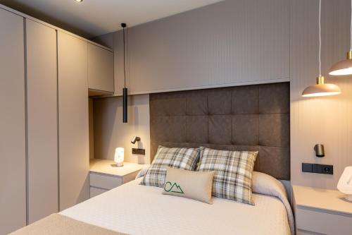 a bedroom with a large bed with two pillows at Cases Cerdanya Mountain Residences in Bellver de Cerdanya 