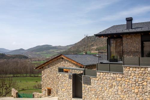 a stone house with a stone wall at Cases Cerdanya Mountain Residences in Bellver de Cerdanya 