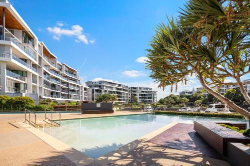 uma piscina em frente a um grande edifício de apartamentos em Allisee Apartments em Gold Coast