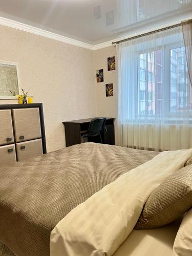 1 dormitorio con cama, escritorio y ventana en Центр. Вул. С. Крушельницької. 2 кімнати, en Ternopilʼ