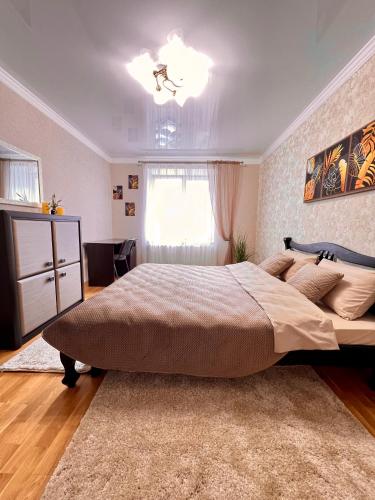 Un dormitorio con una cama grande y una ventana en Центр. Вул. С. Крушельницької. 2 кімнати, en Ternopilʼ