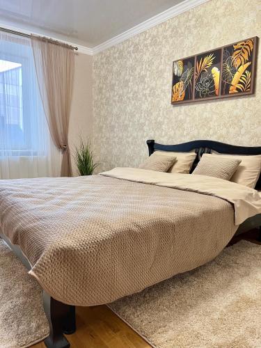 a bedroom with a large bed and a window at Центр. Вул. С. Крушельницької. 2 кімнати in Ternopilʼ