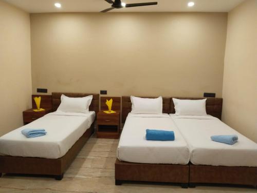 a bedroom with two beds and a ceiling fan at Hotel Windsor Plaza in Hyderabad
