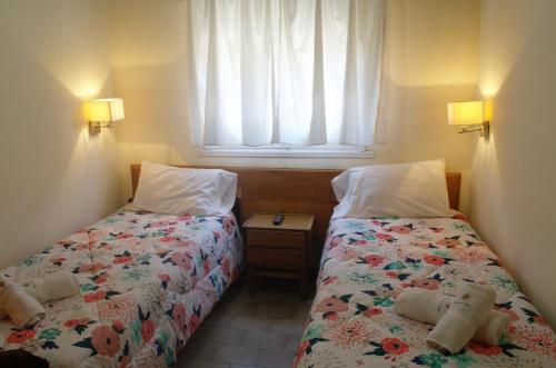 1 dormitorio con 2 camas con ositos de peluche en Hostería Robert en Villa Gesell